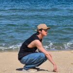 「BTS」Jin、海辺でラフな魅力…たくましい腕に視線集中